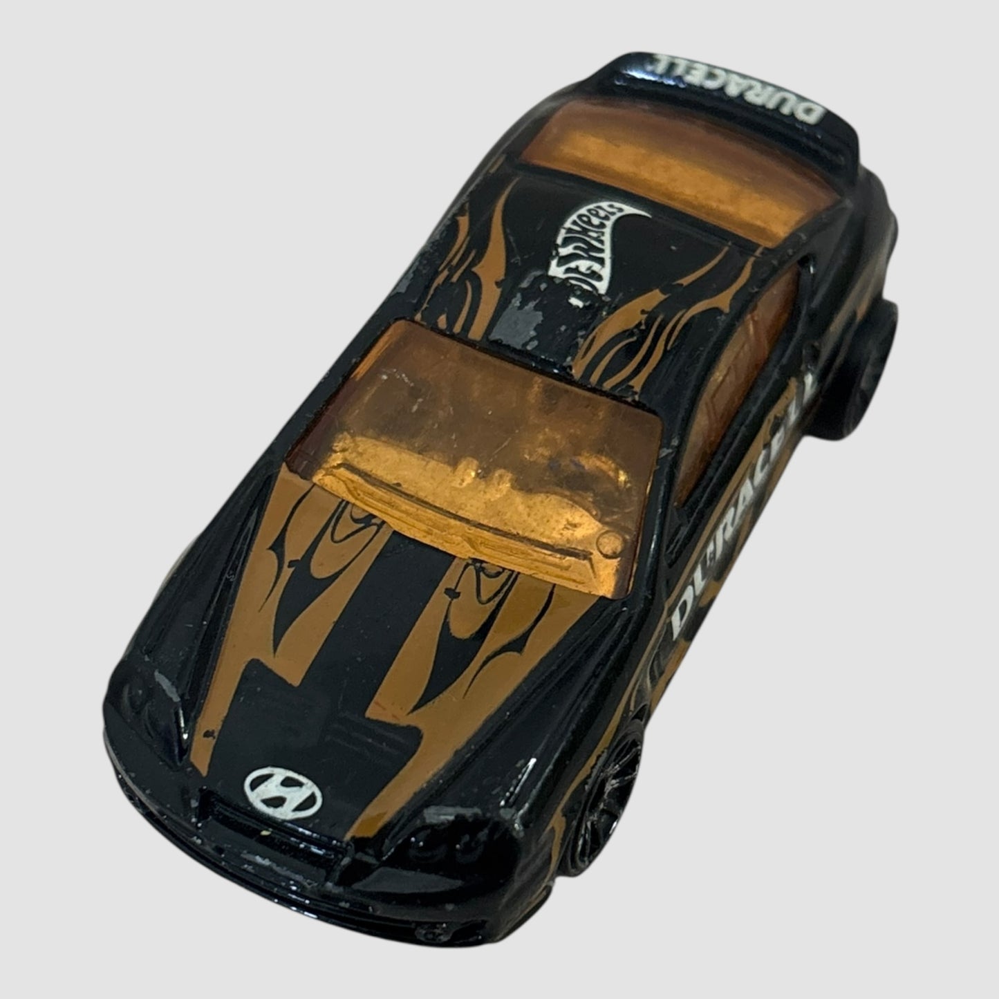 Carro miniatura Hot Wheels Hyundai Tiburon Duracell preto e dourado
