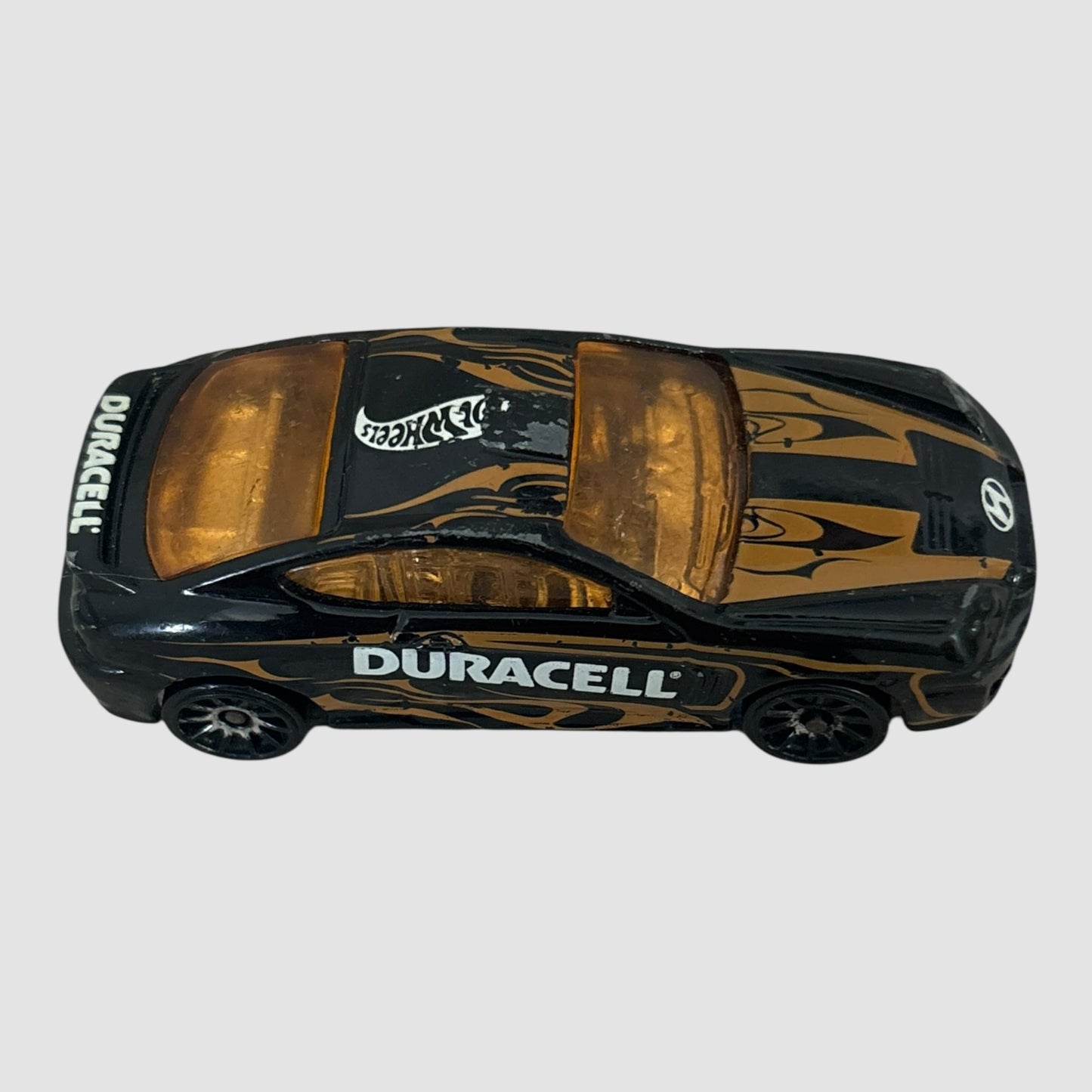 Carro miniatura Hot Wheels Hyundai Tiburon Duracell preto e dourado